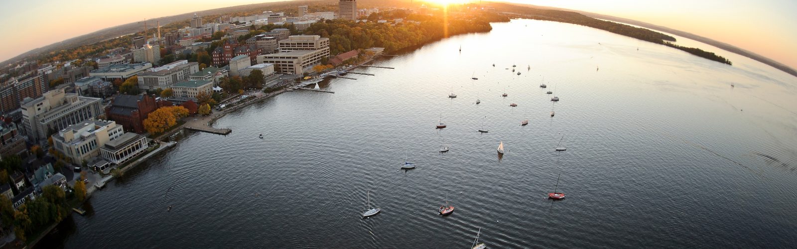 An image of the sun on the horizon over lake Mendota and the Madison isthmus.