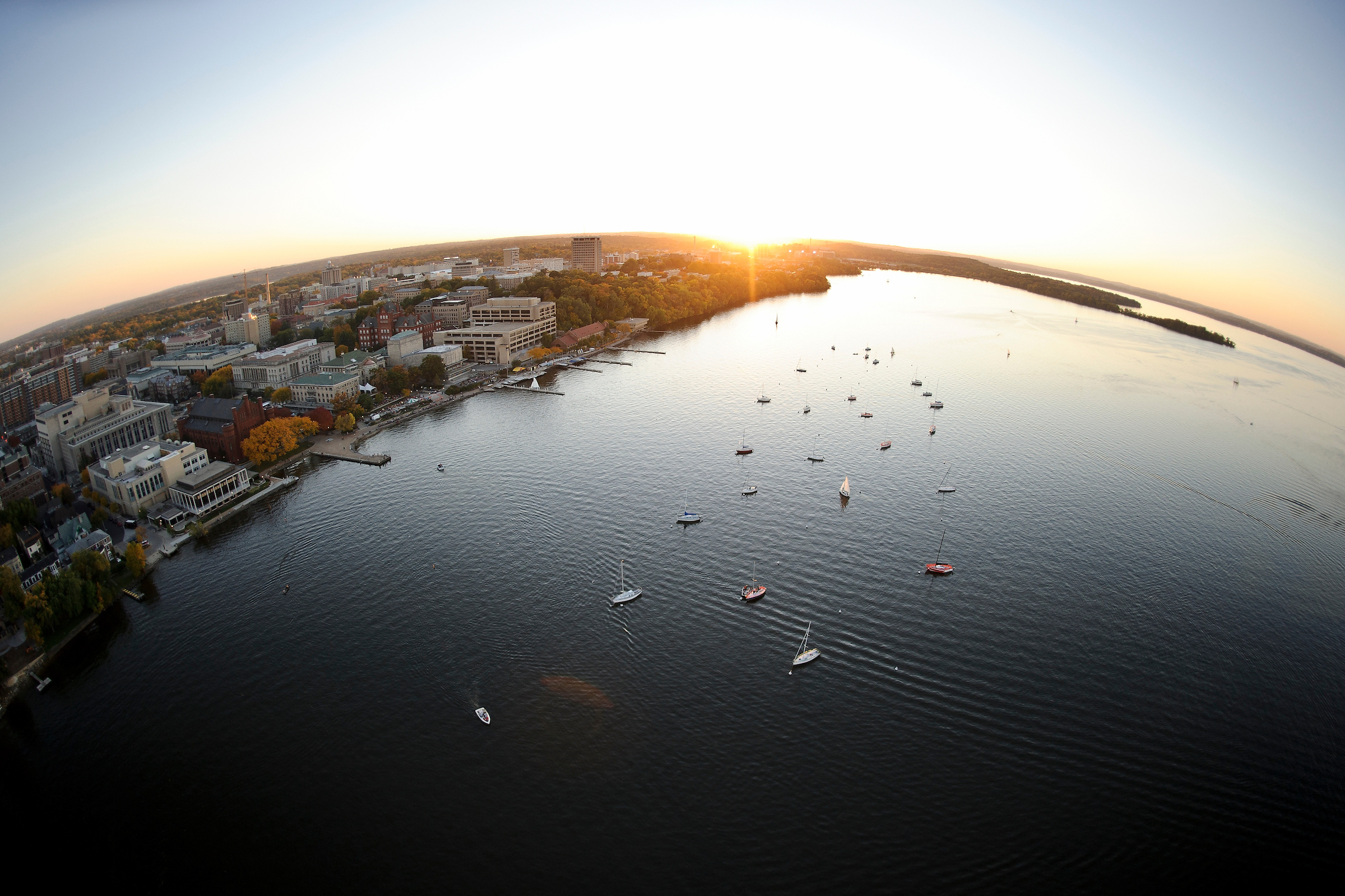 An image of the sun on the horizon over lake Mendota and the Madison isthmus.